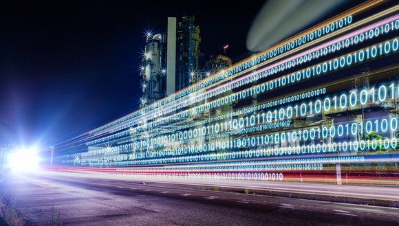 An industrial plant with zeros and ones overlaid on top (digital technology concept). 