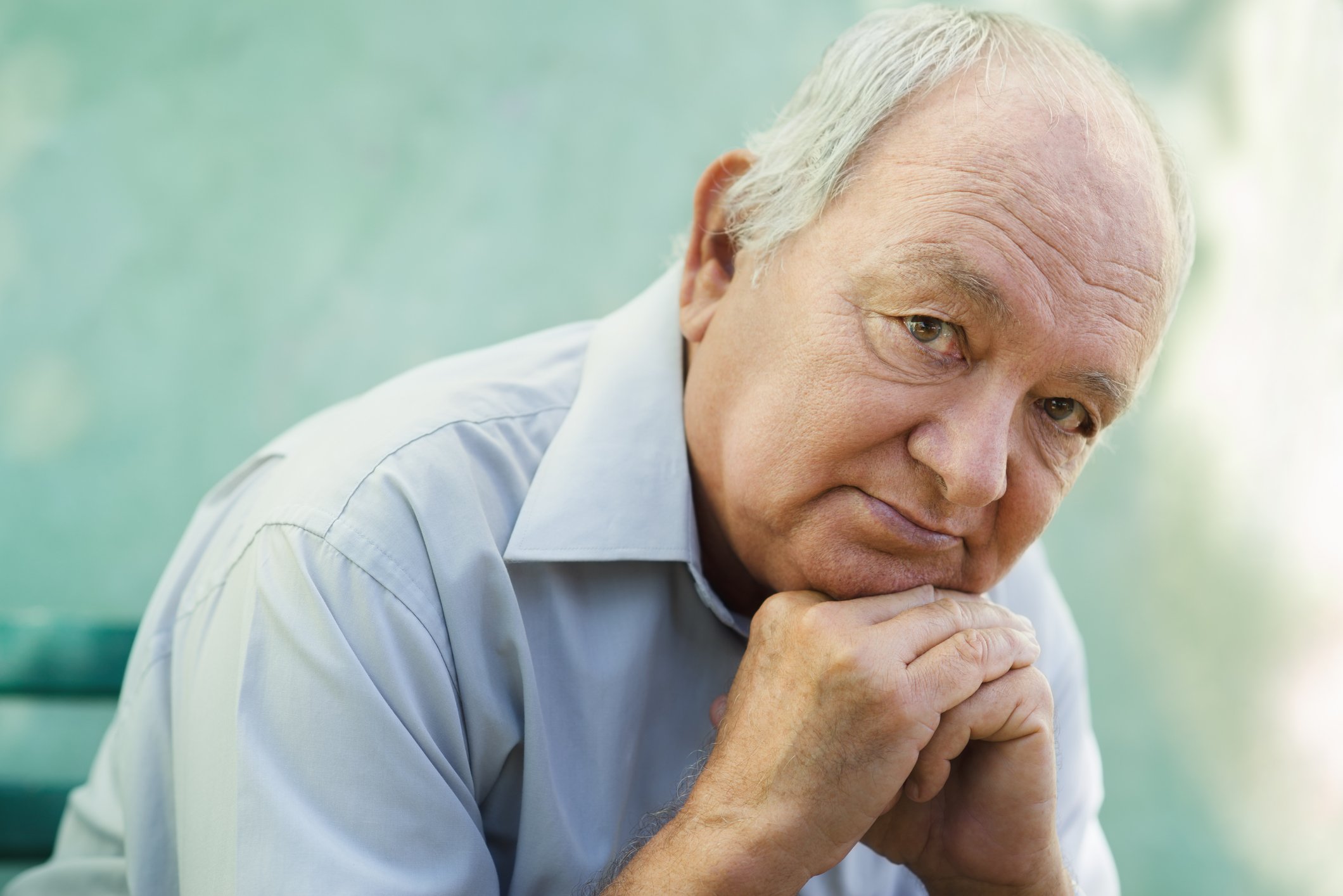 Older man resting his head on his hands