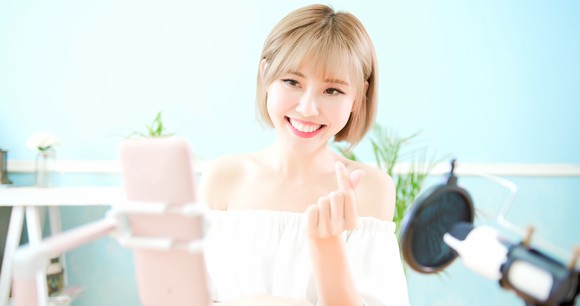 A young woman streams a live video to her viewers.