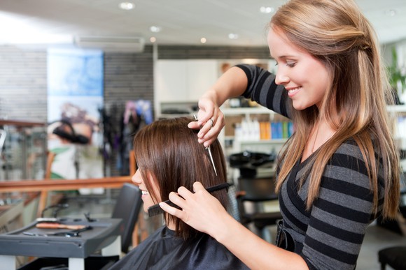 A female salon customer getting a haircut.