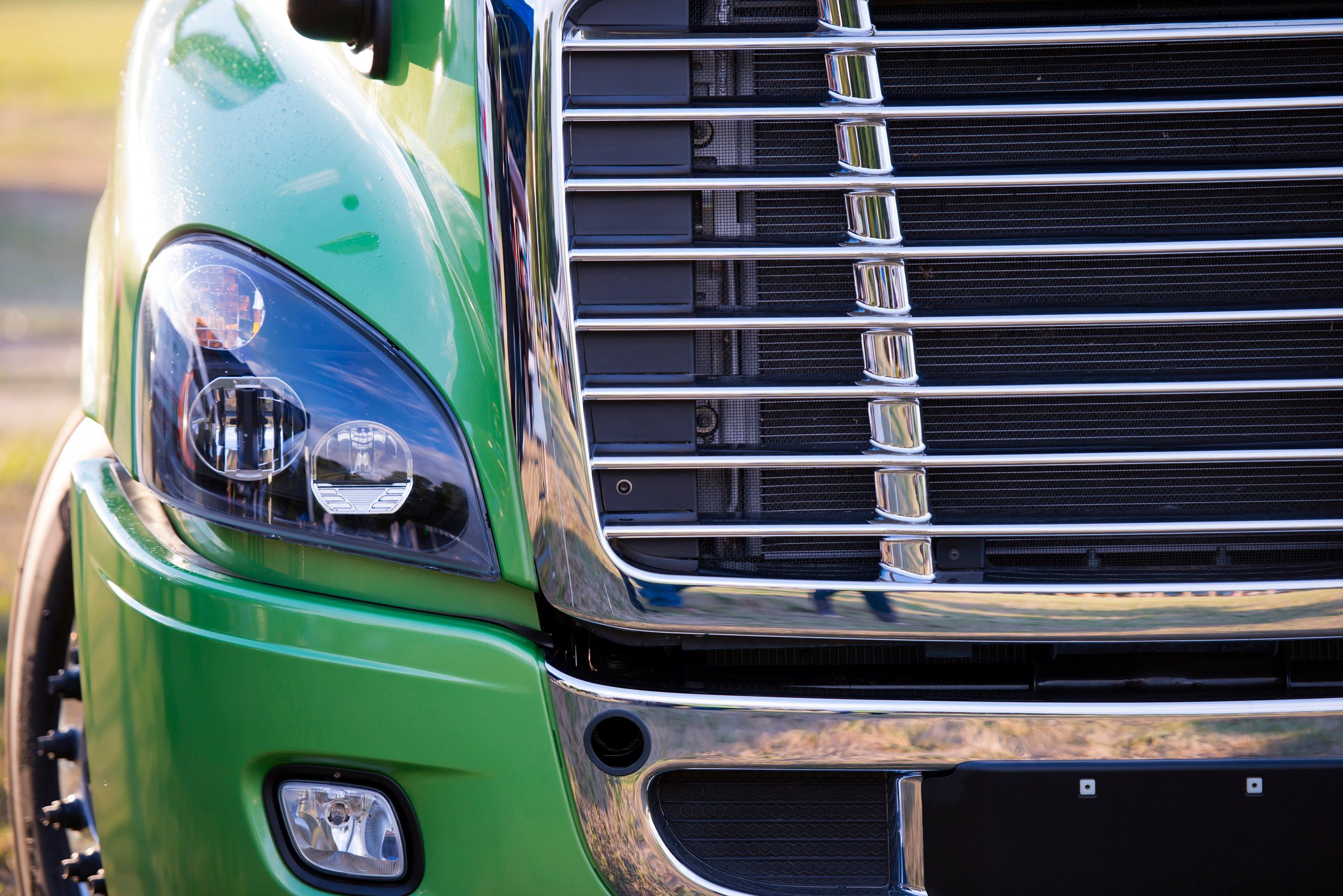Detail of a grille and headlamp in a modern heavy duty semi truck.