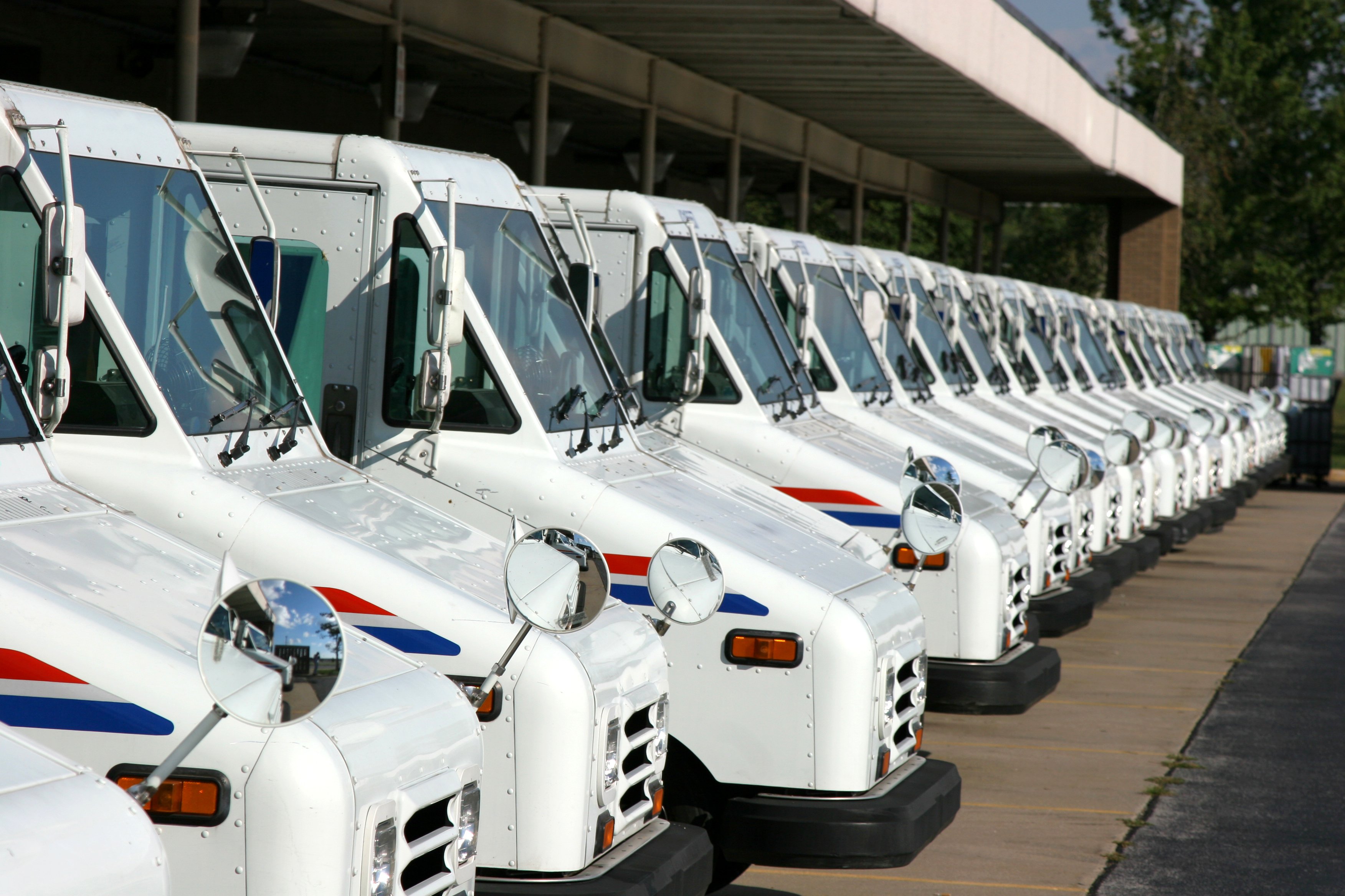Long line of USPS post office trucks