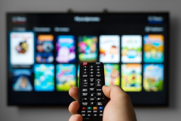 A person controls a smart TV with a remote.