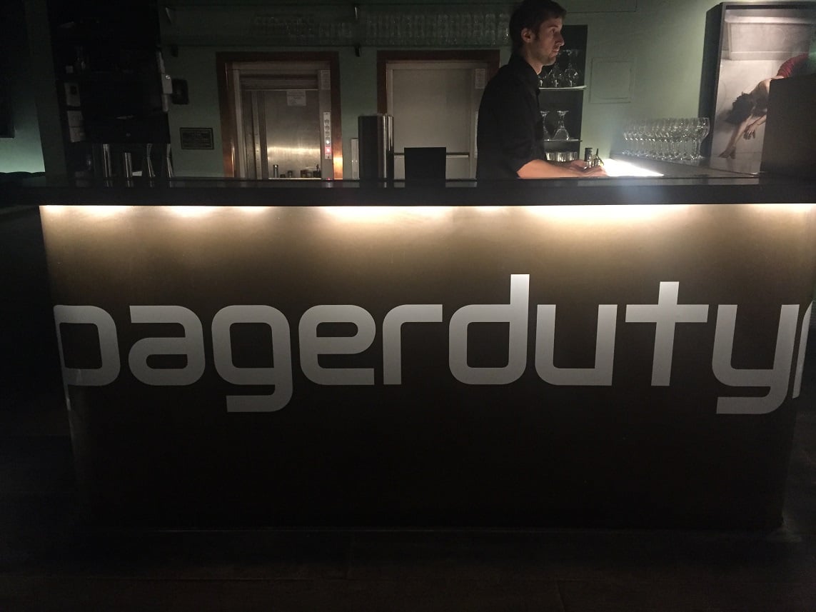 Desk with person behind it and PagerDuty logo on front.