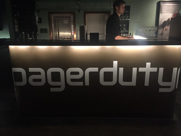 Desk with person behind it and PagerDuty logo on front.