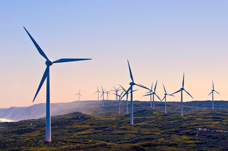 A row of wind turbines along a coast.