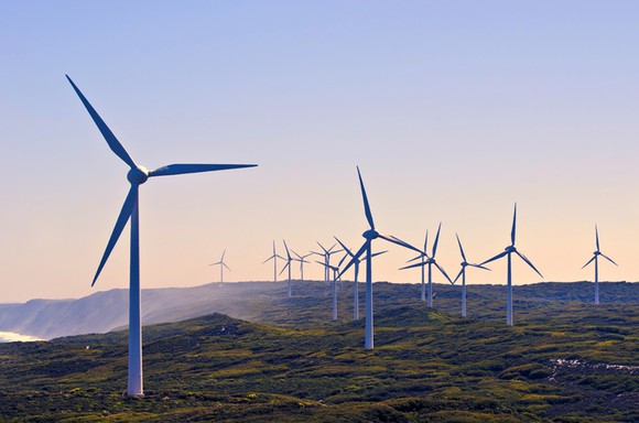 A row of wind turbines along a coast.