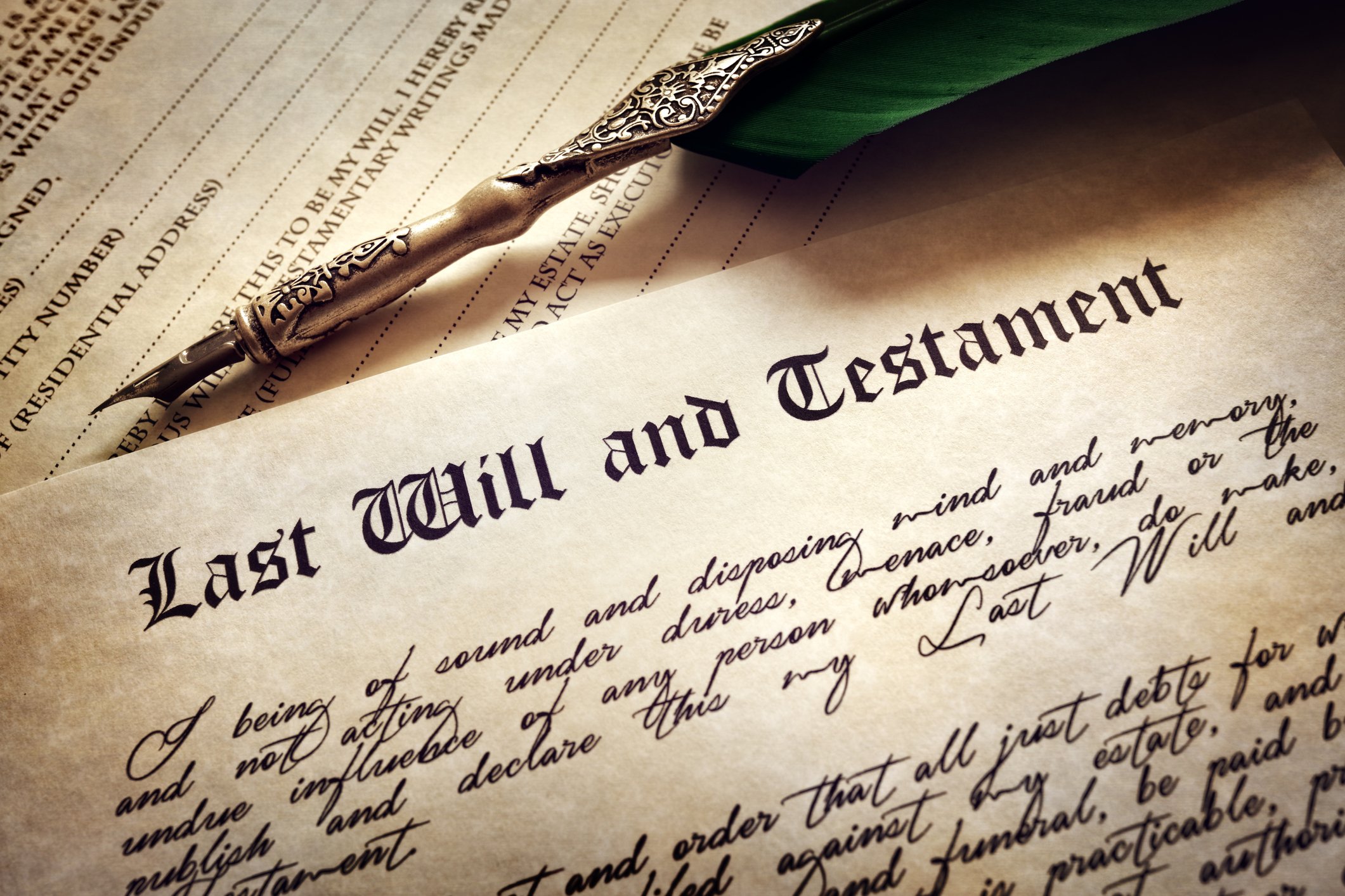 A last will and testament, with a pen above it.