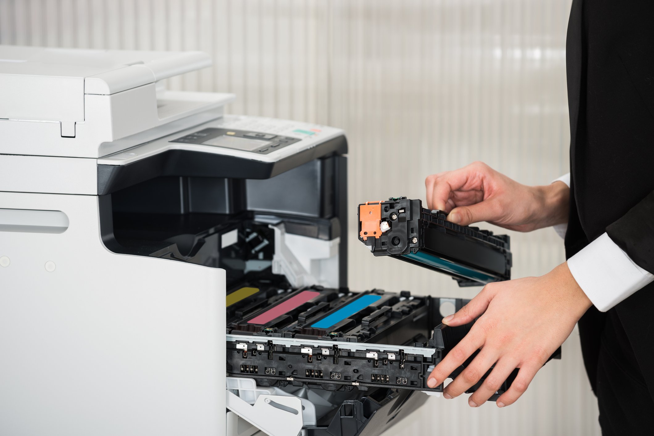Hands changing ink cartridge in an office laser printer
