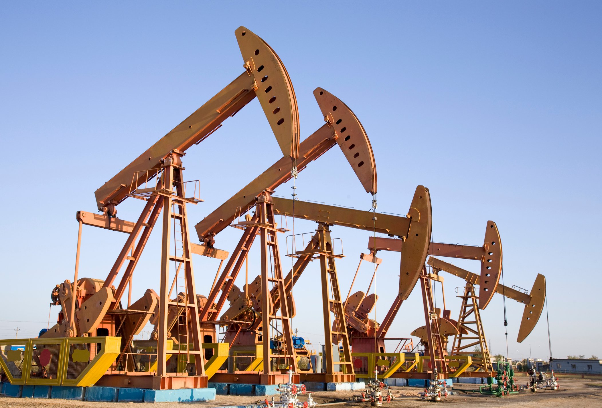 A row of oil pumps in a desert landscape