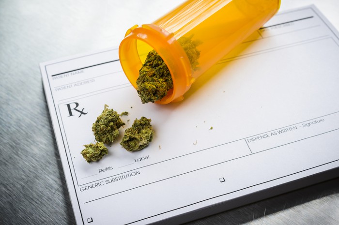 A vial of cannabis spilling onto a prescription