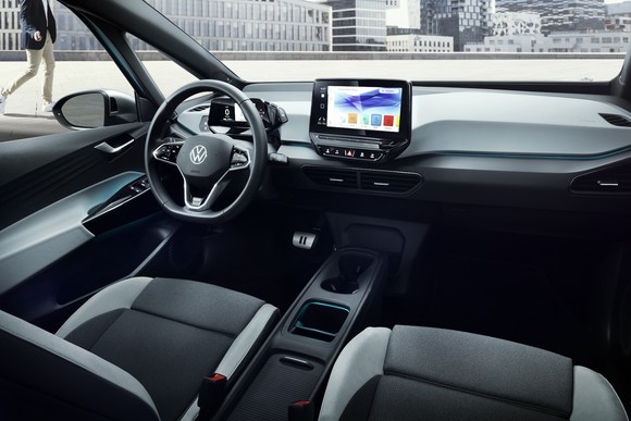A view of the front seats and dashboard of an ID.3, showing minimalist design and a large touchscreen centered on the dash.