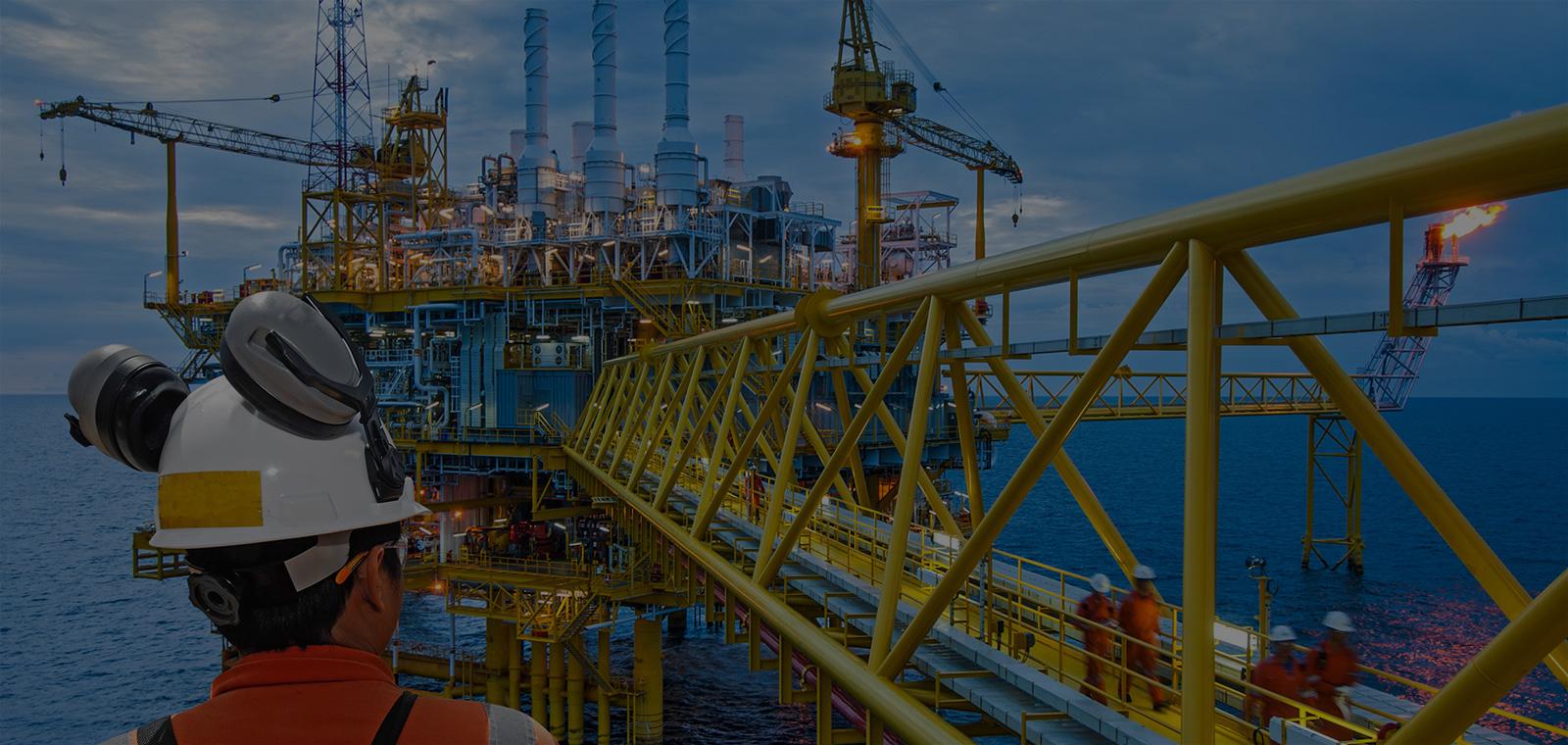 Worker on an offshore rig next to a yellow beam.