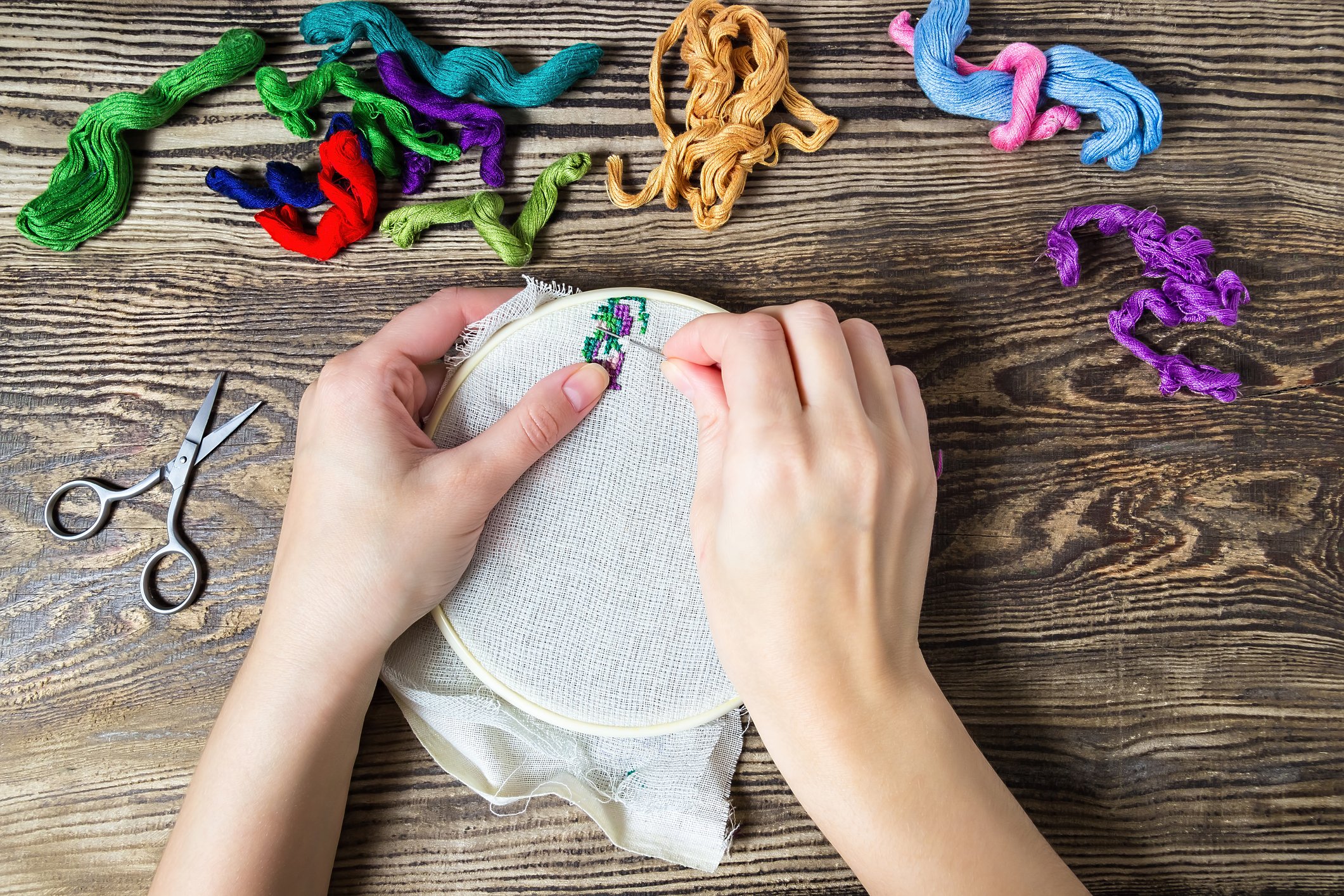Hands beginning a design on an embroidery hoop