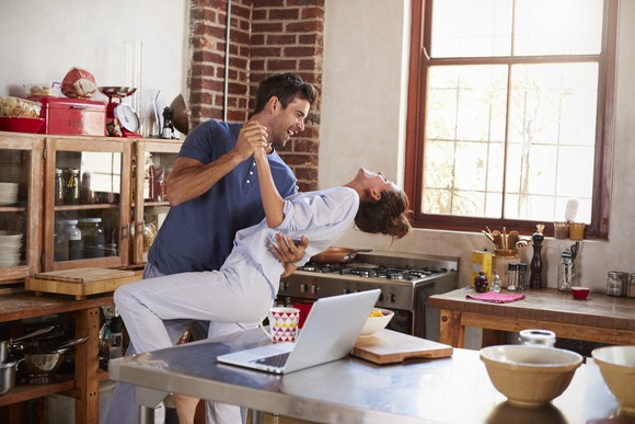 A young couple dances in a home.