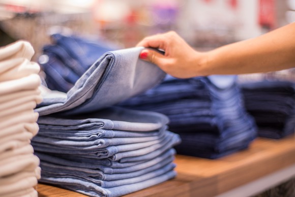 Woman inspecting stack of jeans