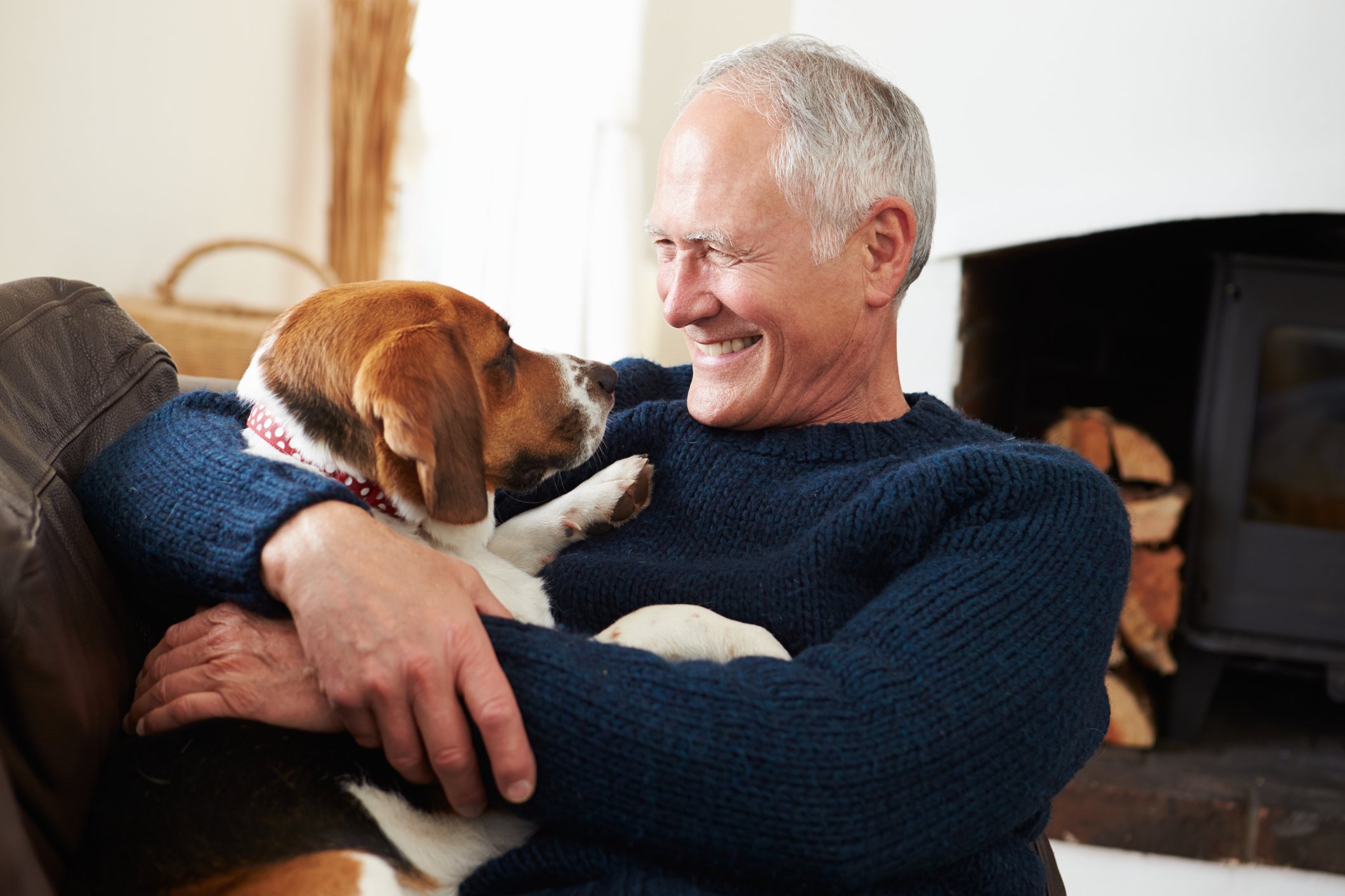 Older man smiling and holding dog