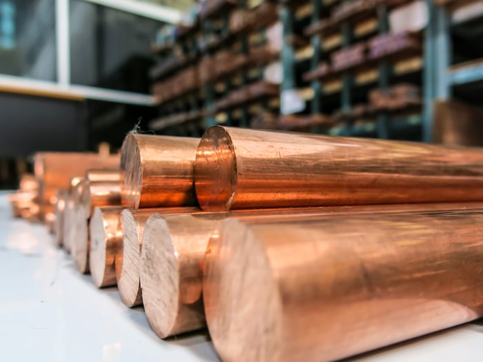 Copper bars lined up on a flat surface.