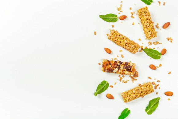 Granola bars and basil leaves on a white background.