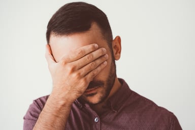 man covering his face_GettyImages-932624558