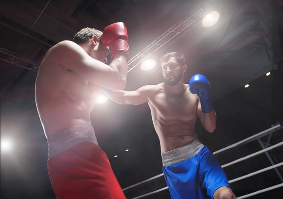 Two men in a boxing ring boxing.
