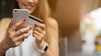 Young woman holding smart phone and credit card