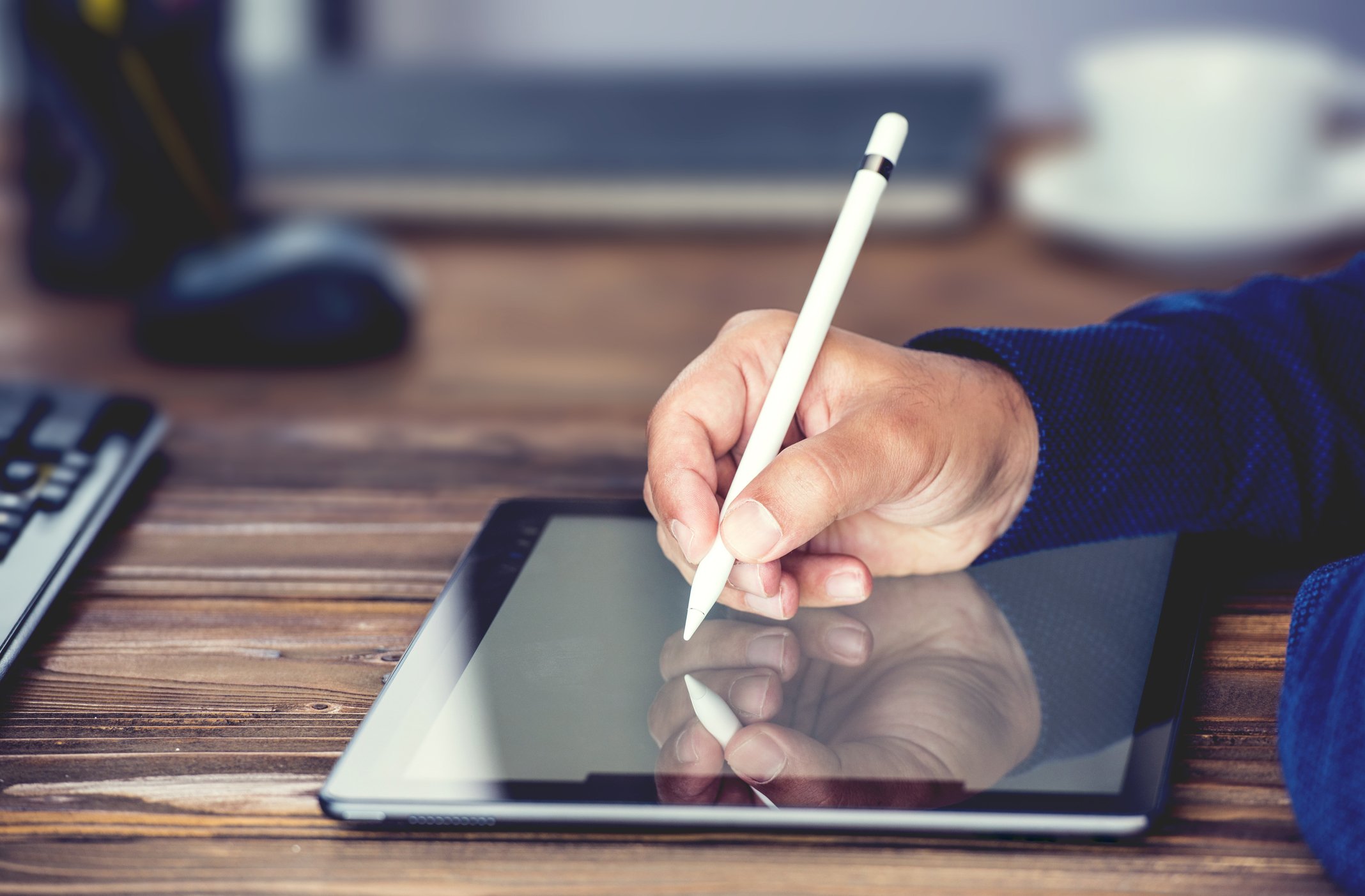 A man interacts with a tablet using a stylus pen.