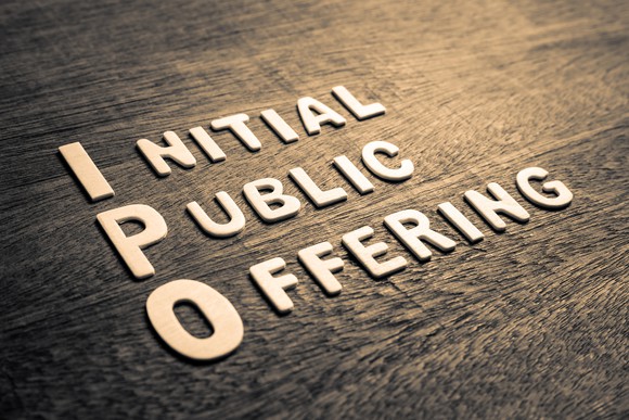 The words initial public offering with capitalized I, P, and O printed on a manufactured wood floor. 