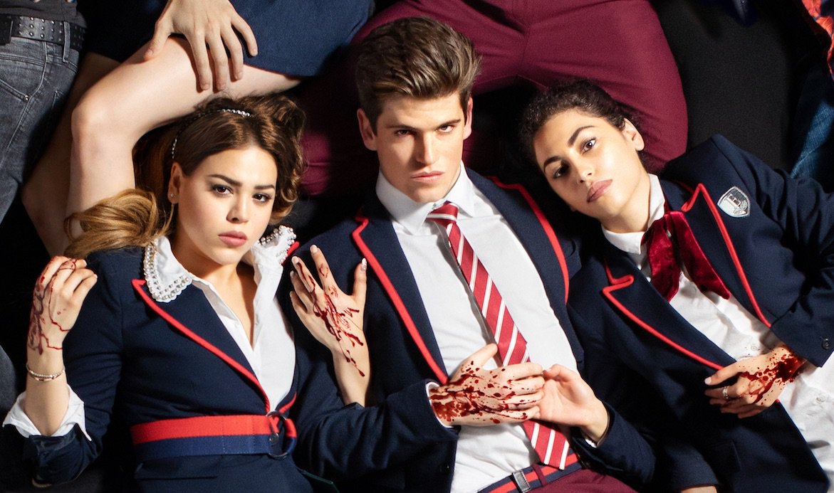 The cast of Elite in their prep school uniforms with blood on their hands.
