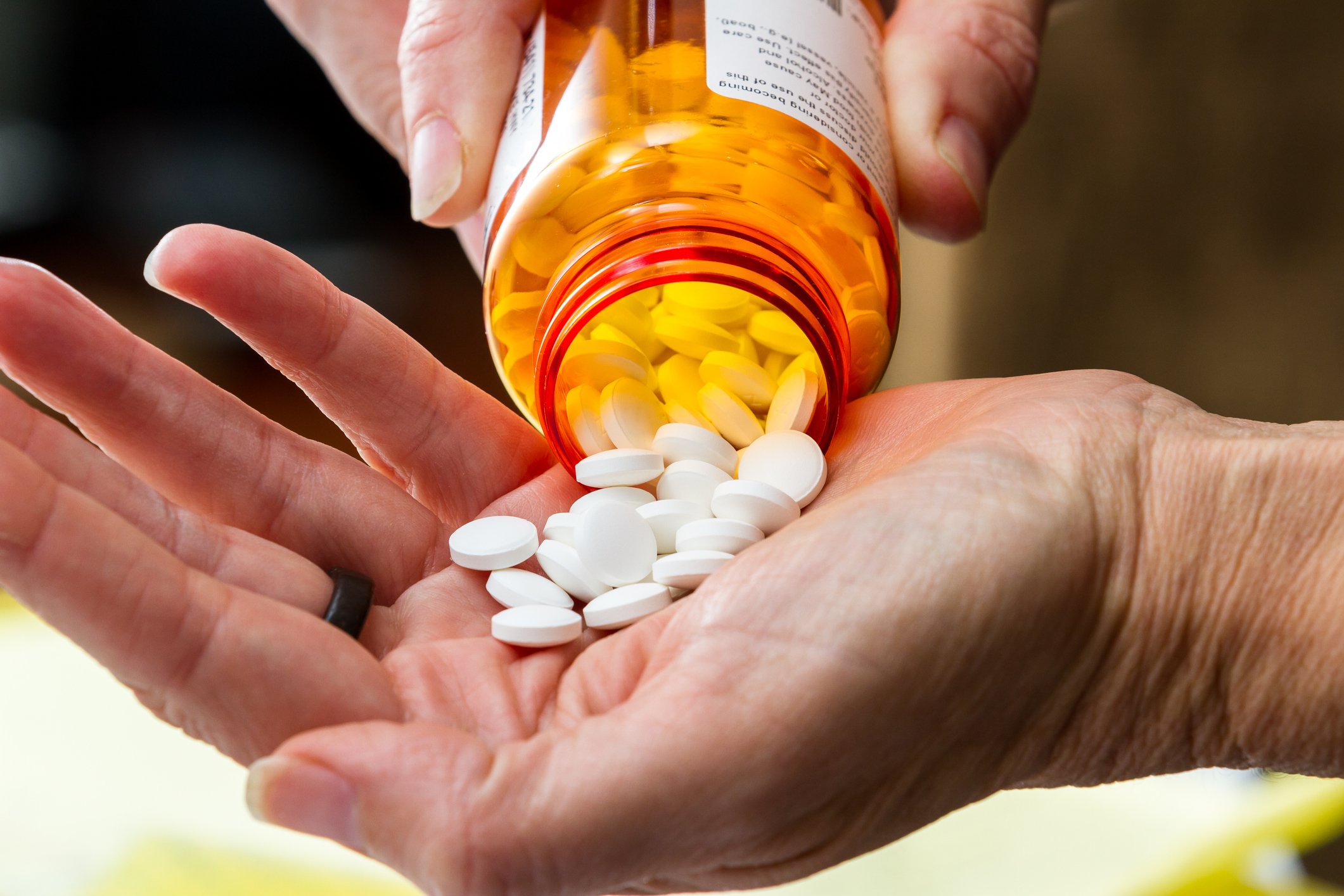 Prescription bottle pouring pills into a hand