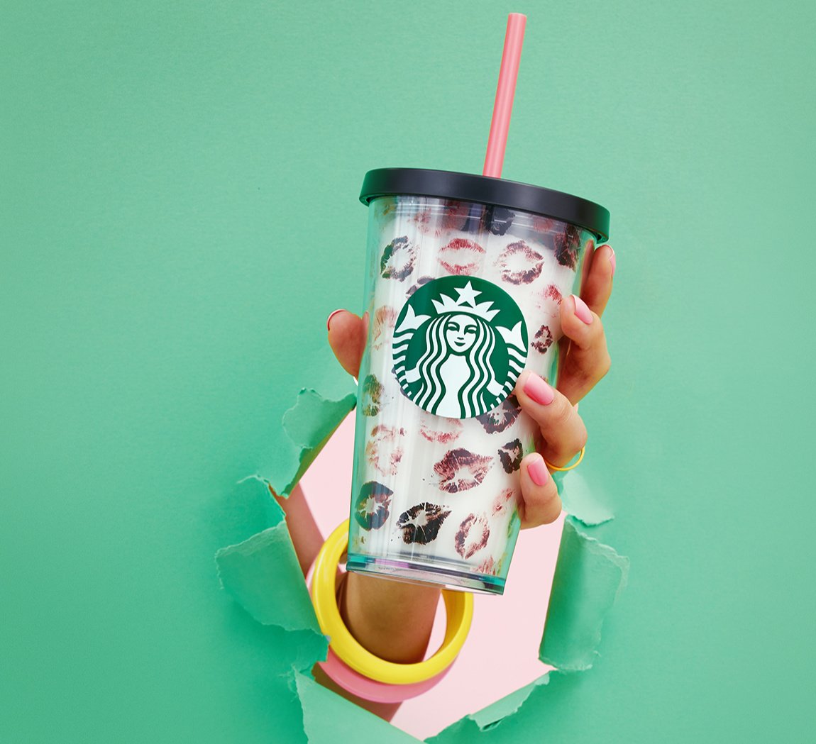 A hand holds up one of the Rachel Zoe collection cups.