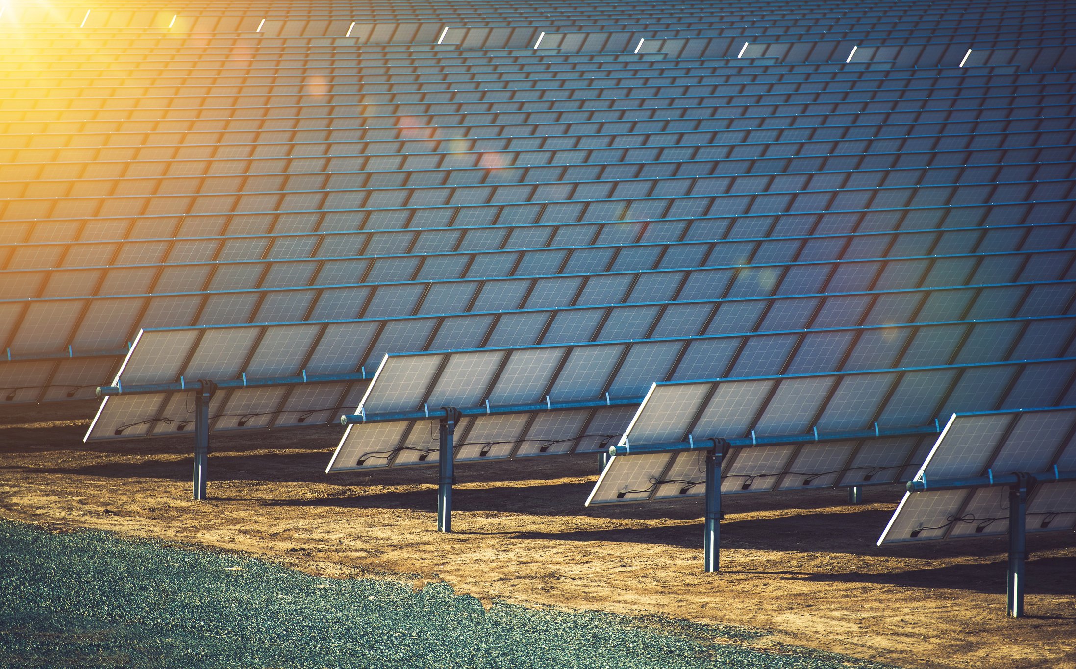 Rows of solar panels with a ray of sunshine in the corner.