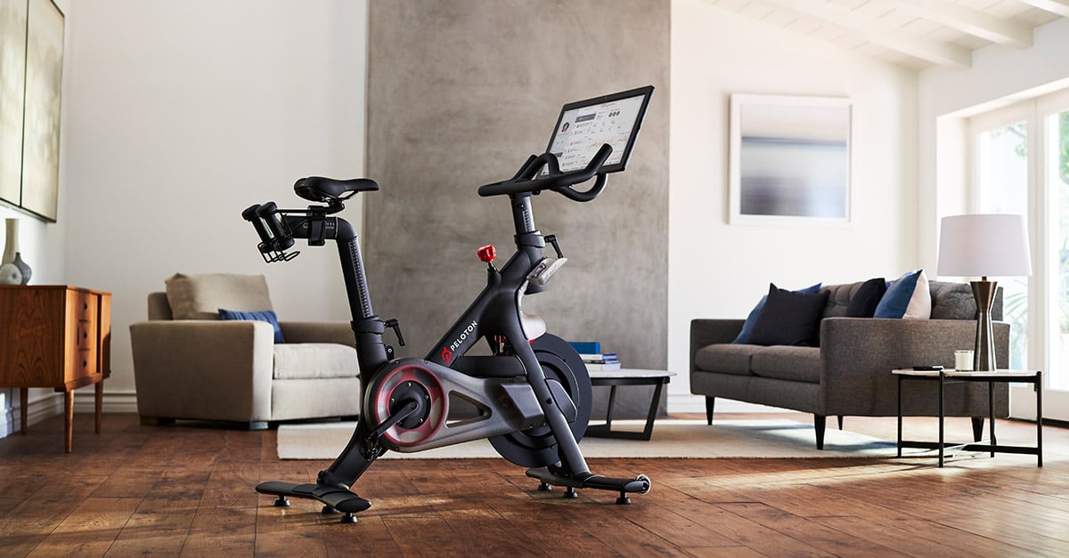 A Peloton Bike and touch screen on display in a living room.