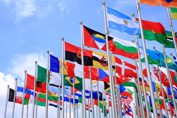 Flags of multiple countries against a blue sky background