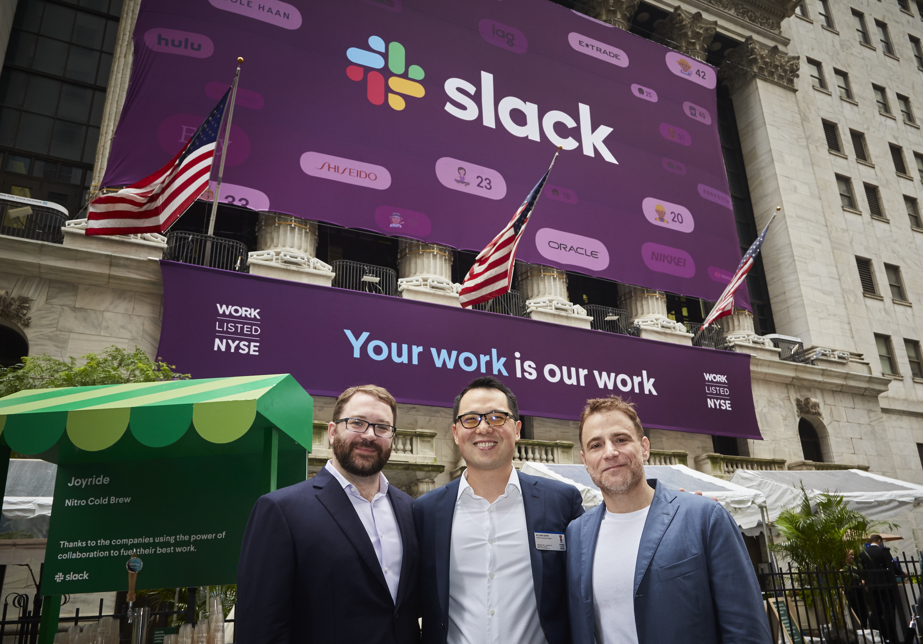 Slack co-founders and CFO at NYSE in front of a Slack sign