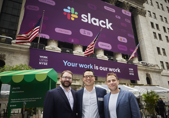 Slack co-founders and CFO at NYSE in front of a Slack sign