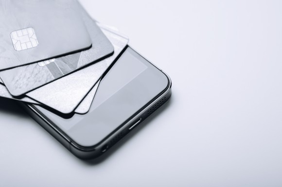 A smartphone with credit cards on top of it.