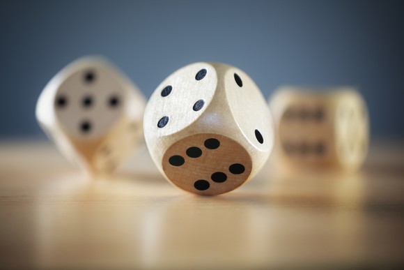 Wooden dice, one in foreground and two in a blurred background