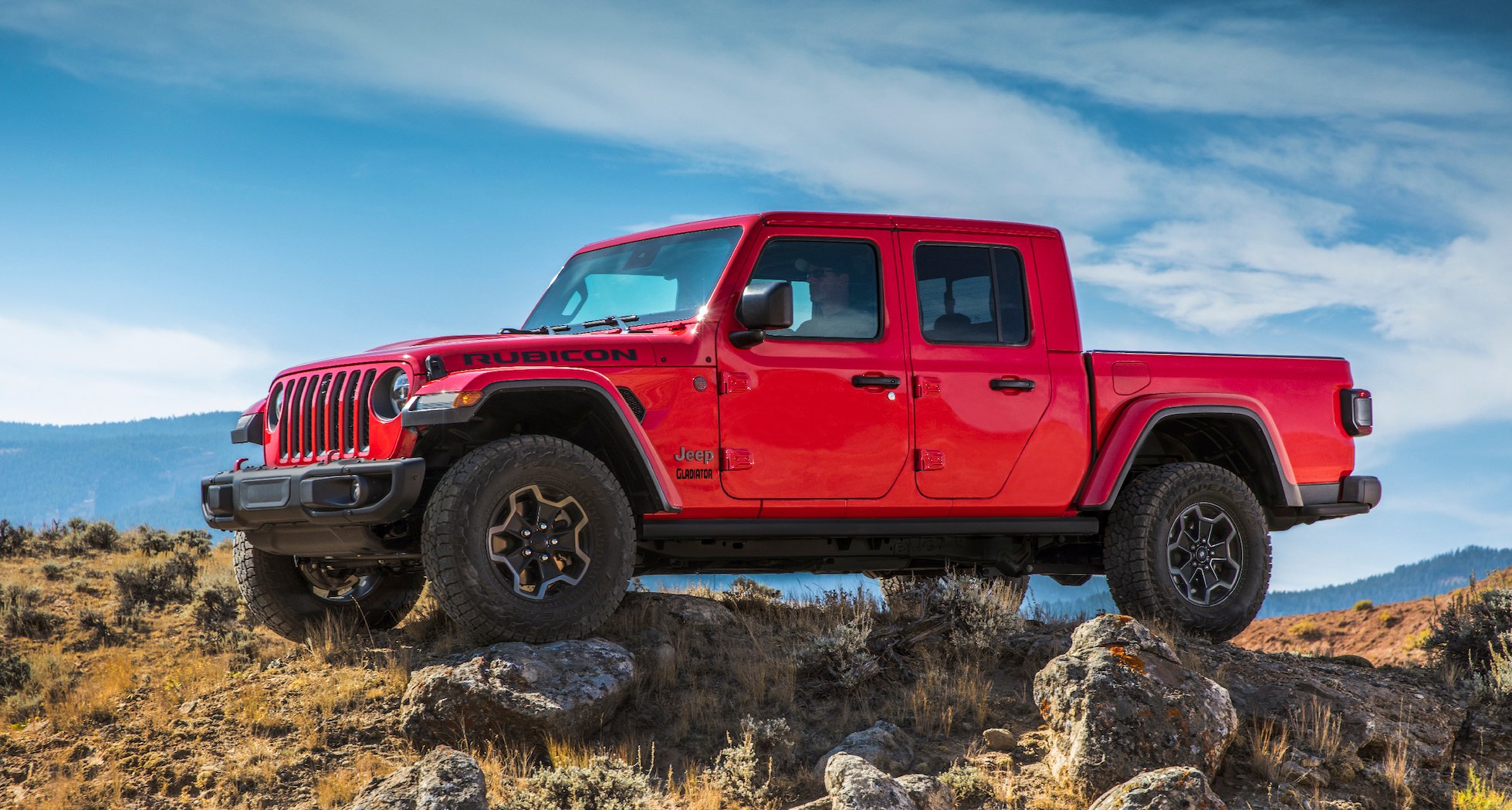 A red 2020 Jeep Gladiator, an off-road pickup truck with distinctive Jeep styling.