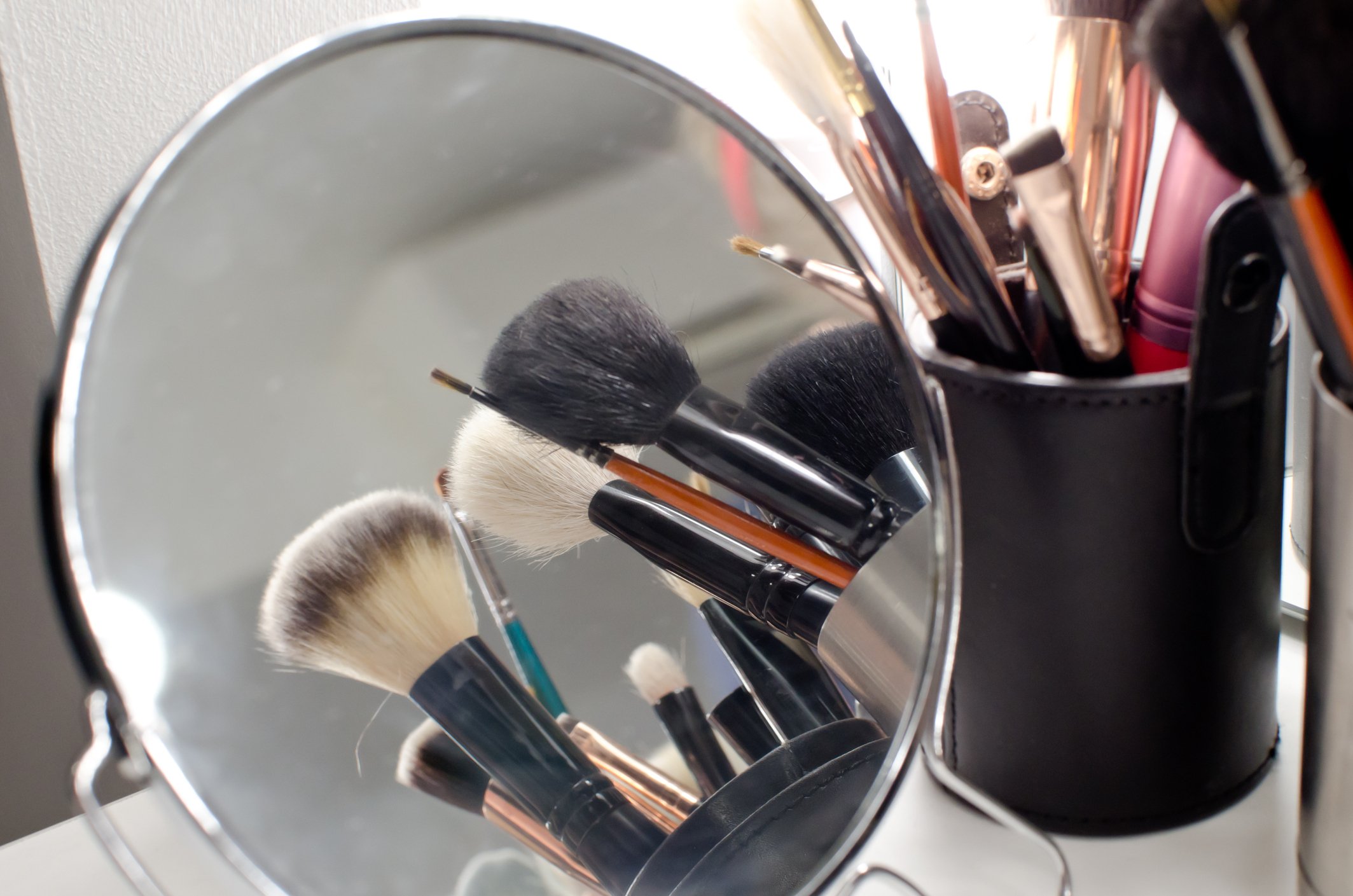 Makeup brushes and a mirror.