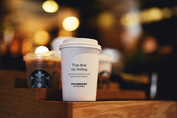 Starbucks cups sitting in a tray for pickup at a store.