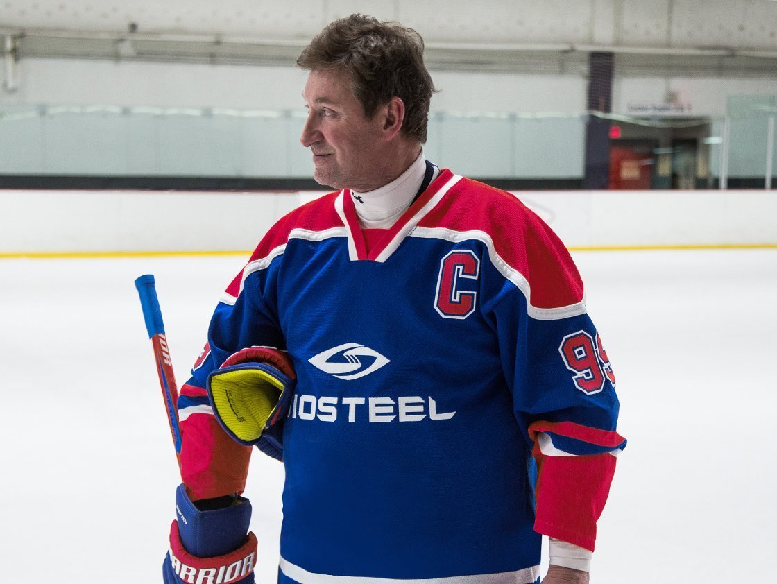 Wayne Gretzky modeling a BioSteel hockey jersey in an ice rink. 