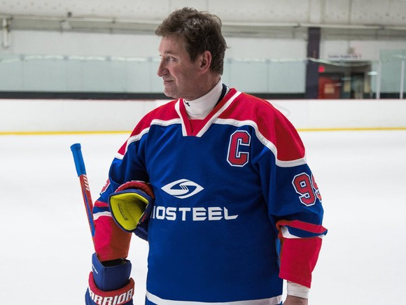 Wayne Gretzky modeling a BioSteel hockey jersey in an ice rink. 