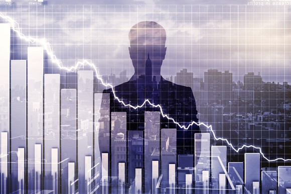 A silhouette of a man looking over a stock chart.
