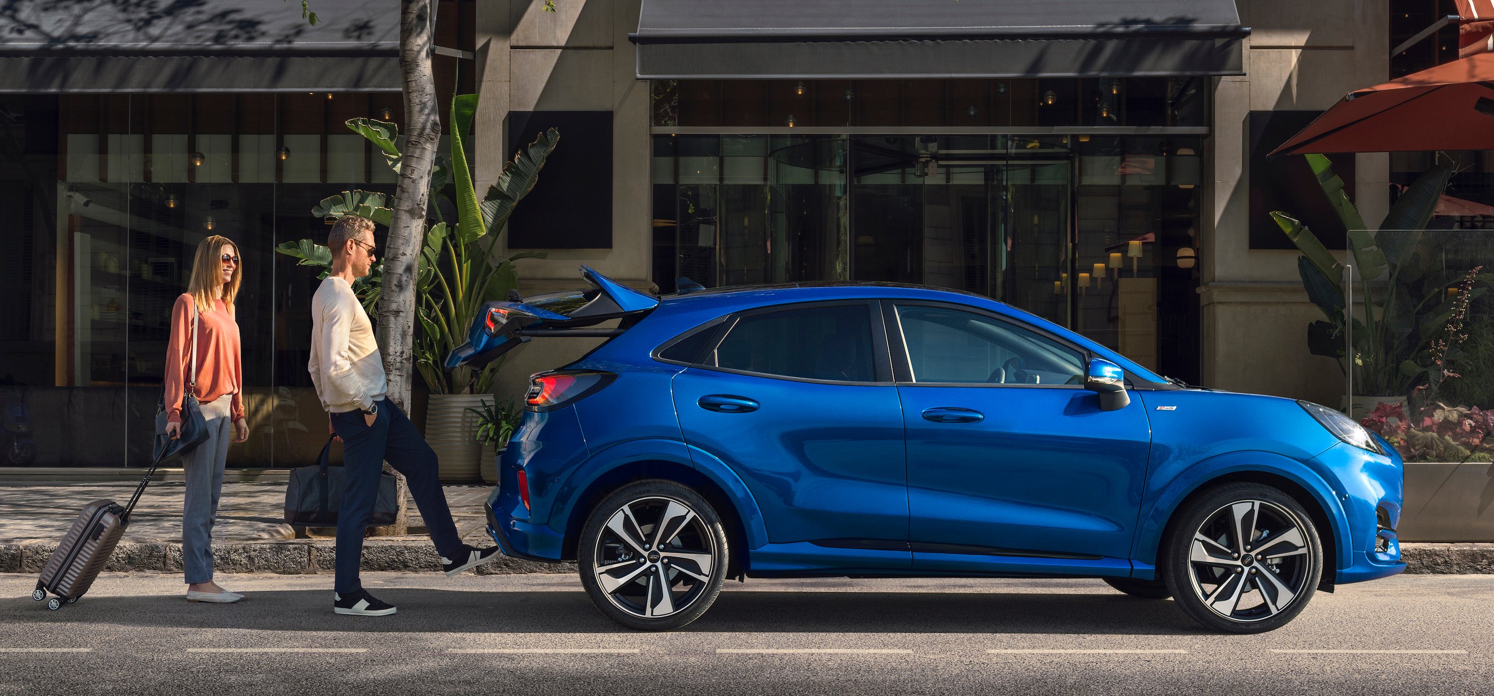 A blue 2020 Ford Puma shown in side view, with two people standing nearby