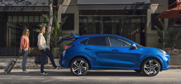 A blue 2020 Ford Puma shown in side view, with two people standing nearby