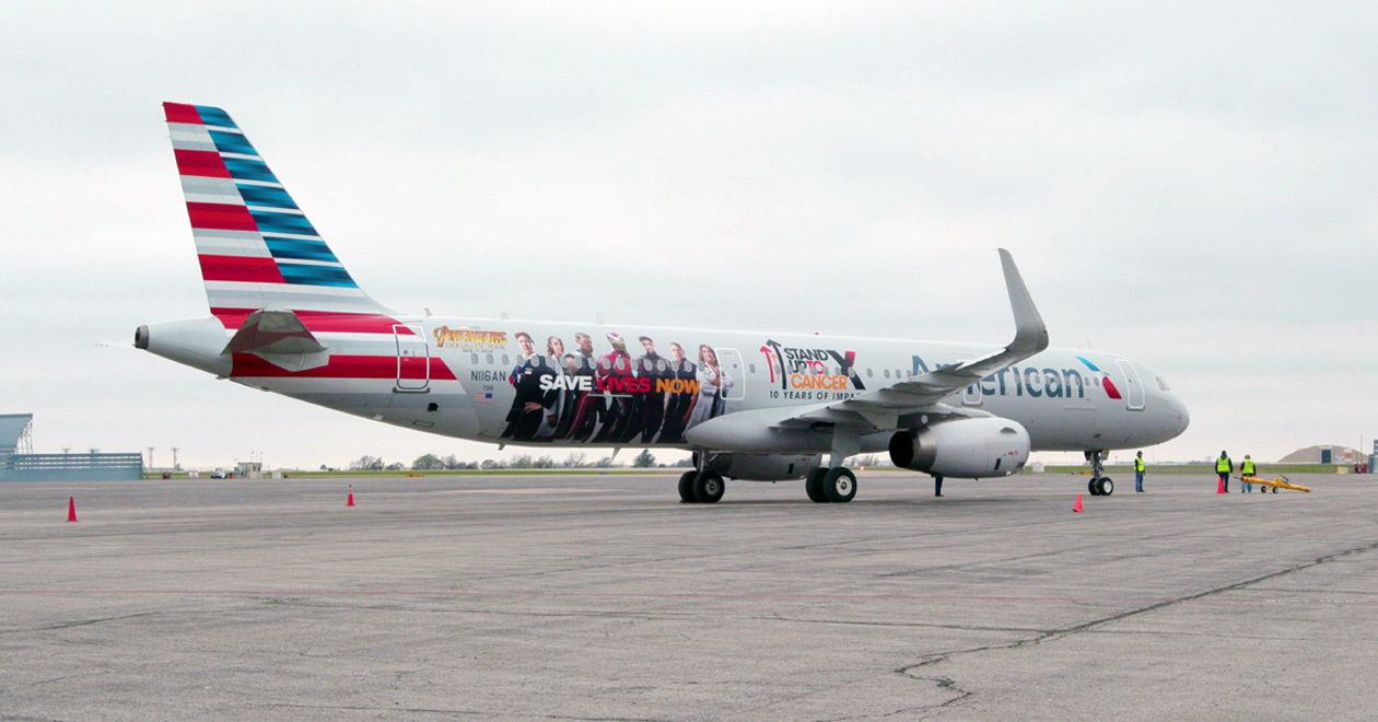 American Airlines jet with American flag and other graphics, on an airport taxiway.