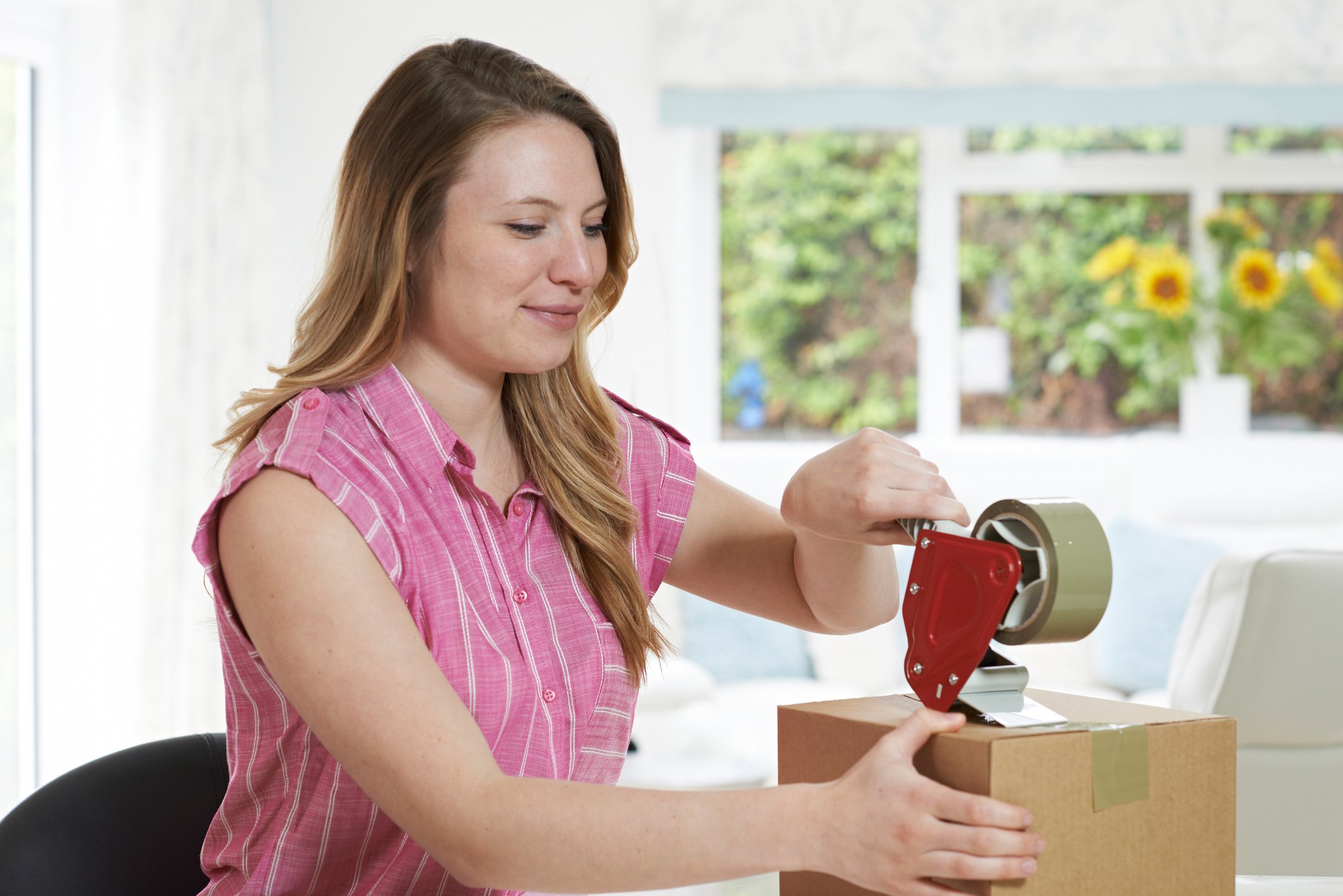 Woman wrapping box in shipping tape