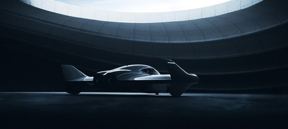 The Porsche and Boeing flying car concept, cloaked in shadow inside a futuristic looking hangar.