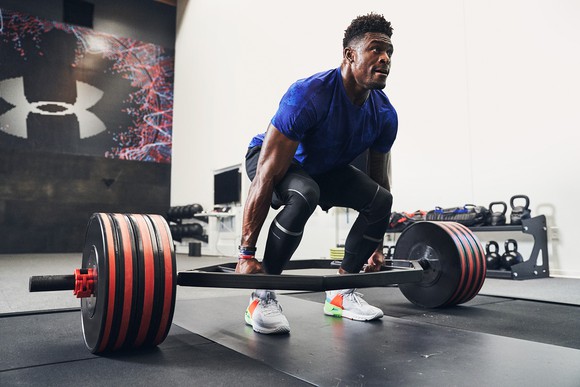 Weight lifter attempting to lift a huge barbell of weight.
